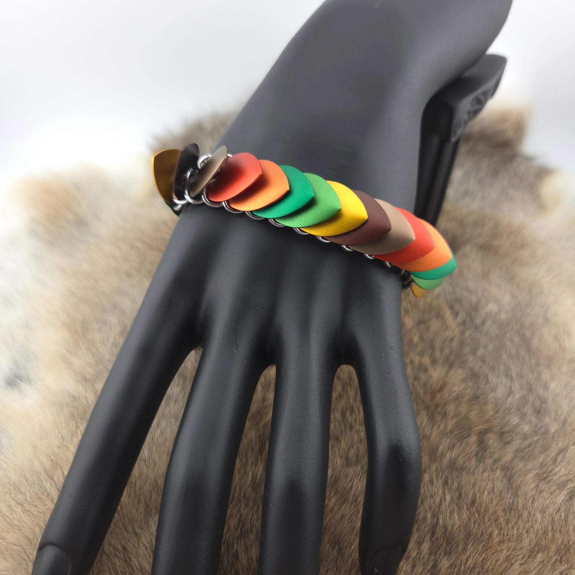 Dragon Scale Bracelet, with a stainless steel spine, premium anodized aluminum scales, and a solid stainless steel spring clasp shaped as a Dragon head.