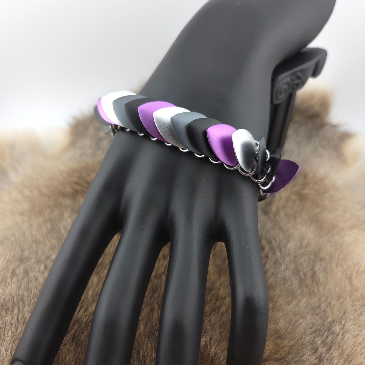 Dragon Scale Bracelet, with a stainless steel spine, premium anodized aluminum scales, and a solid stainless steel spring clasp shaped as a Dragon head.