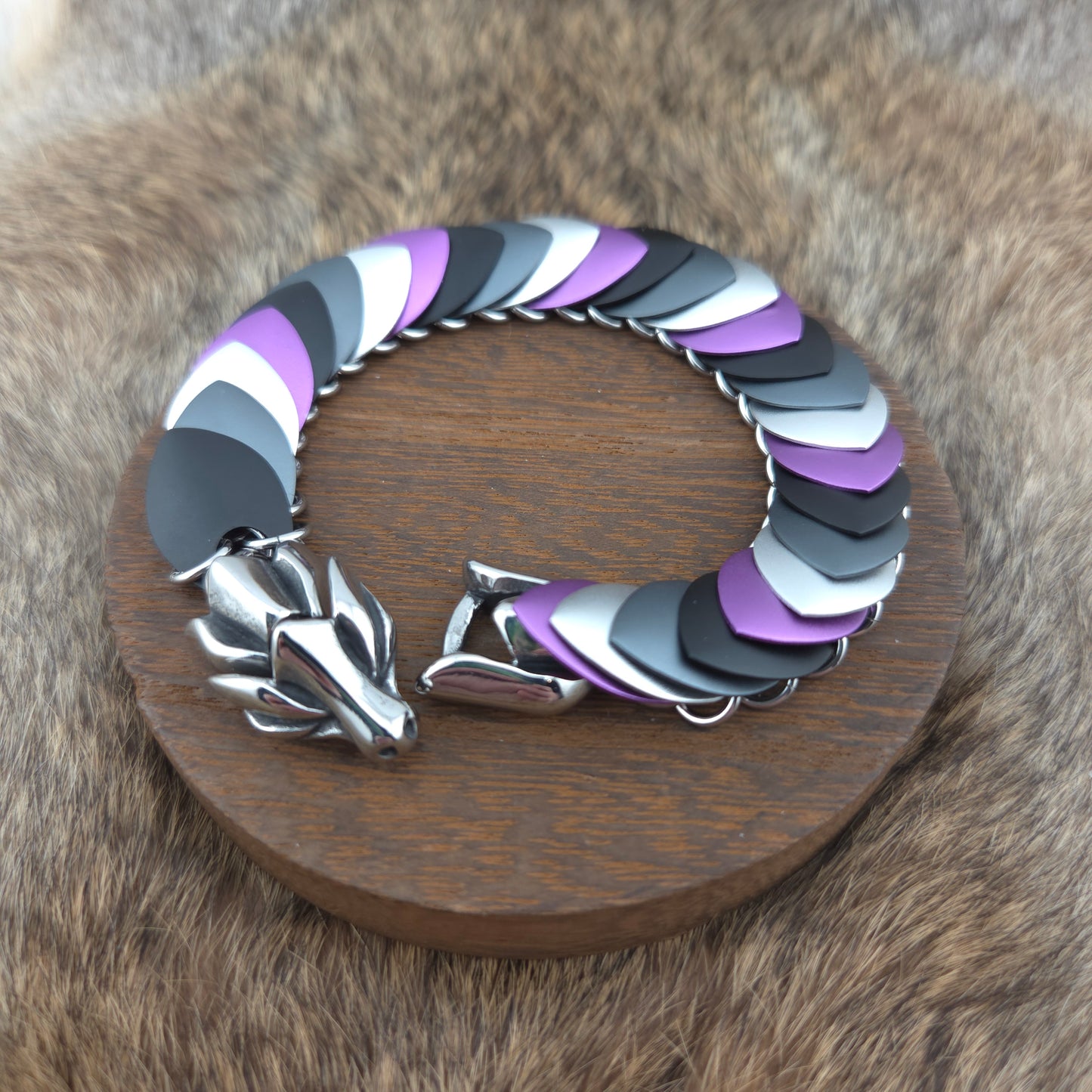 Dragon Scale Bracelet, with a stainless steel spine, premium anodized aluminum scales, and a solid stainless steel spring clasp shaped as a Dragon head.