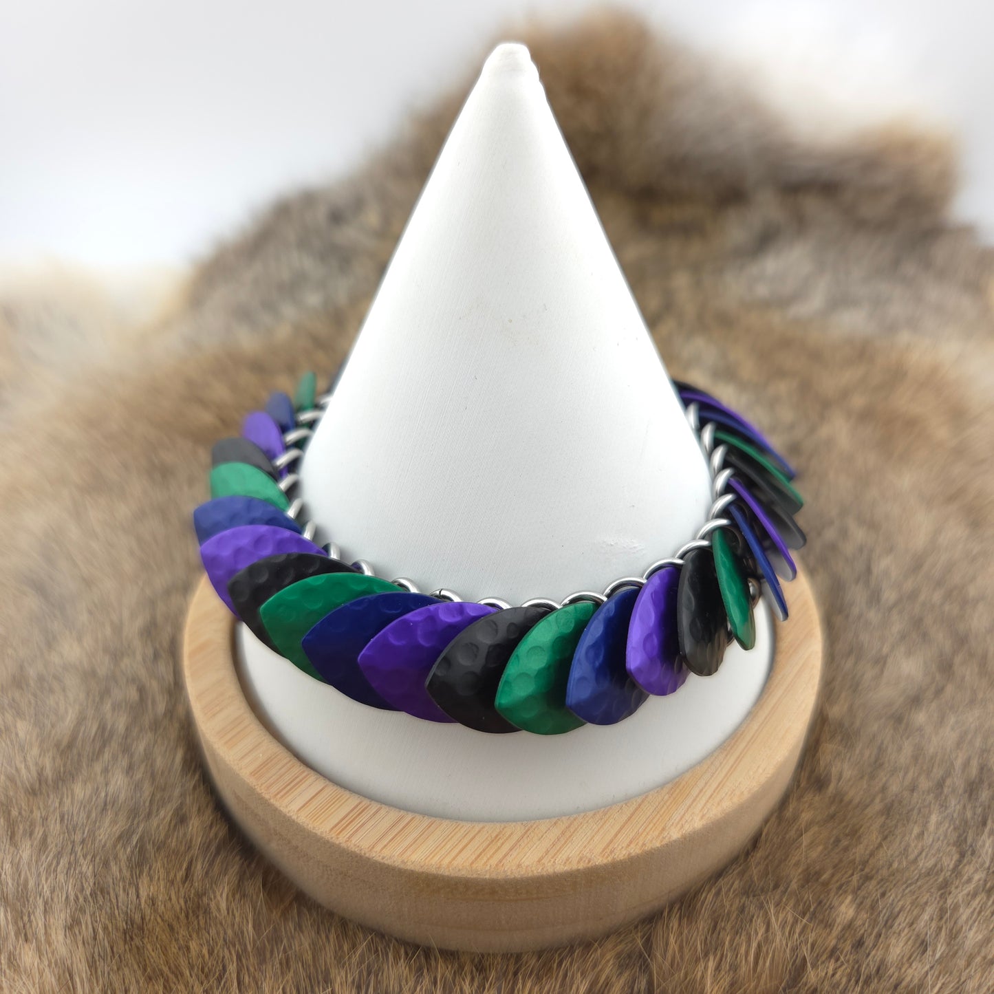 A dragon scale bracelet, handwoven with aluminum scales on a stainless steel spine with a solid stainless steel spring clasp.