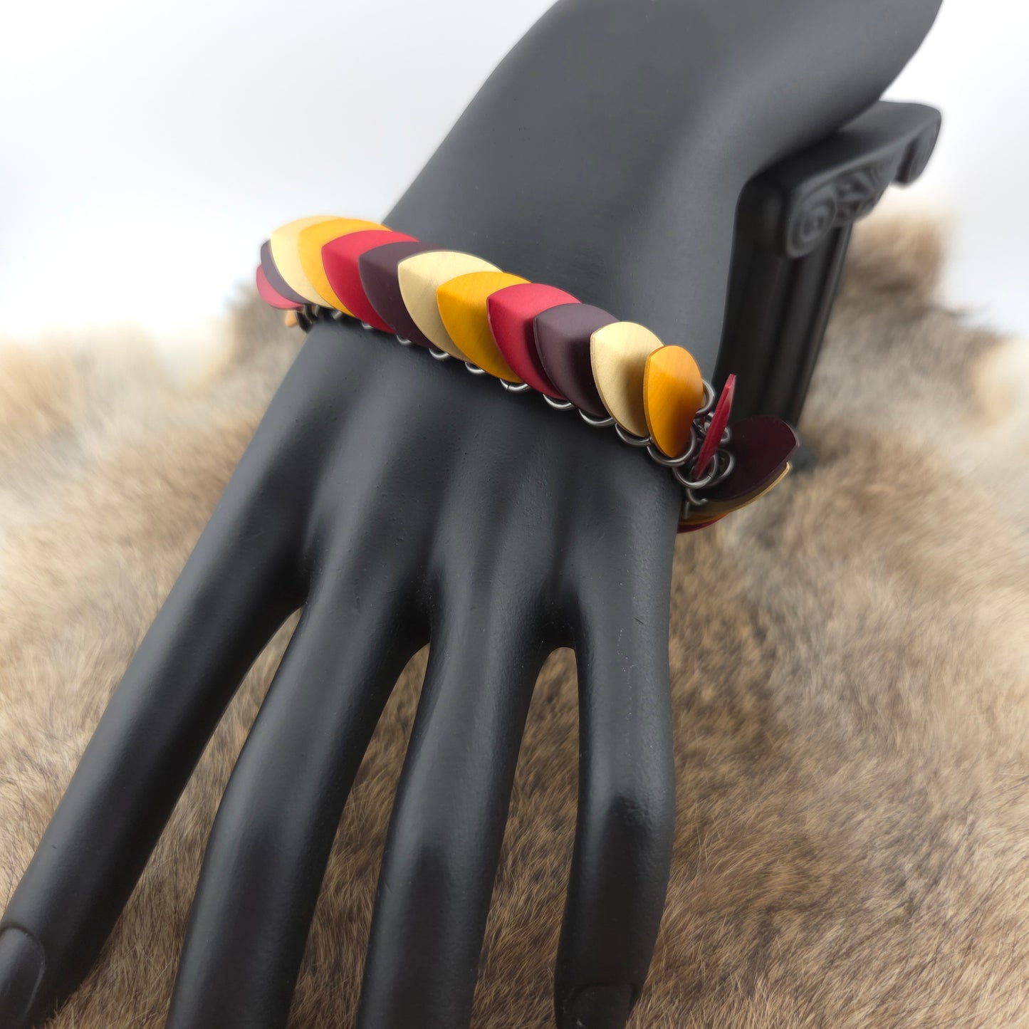 Dragon Scale Bracelet, with a stainless steel spine, premium anodized aluminum scales, and a solid stainless steel spring clasp shaped as a Dragon head.