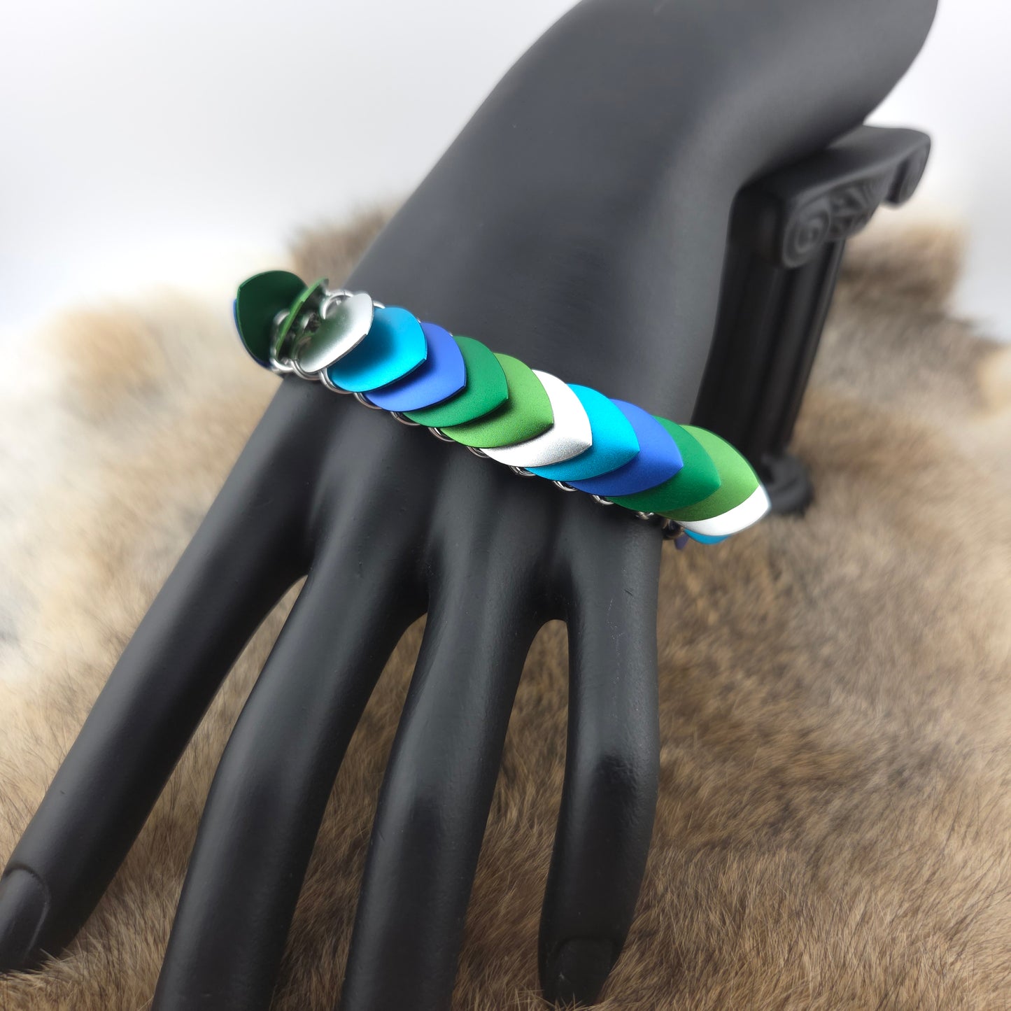 Dragon Scale Bracelet, with a stainless steel spine, premium anodized aluminum scales, and a solid stainless steel spring clasp shaped as a Dragon head.