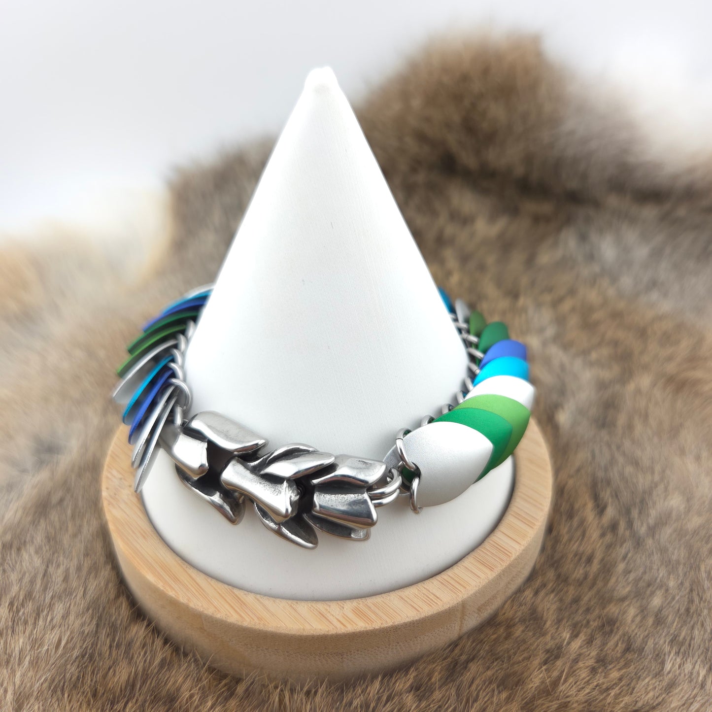 Dragon Scale Bracelet, with a stainless steel spine, premium anodized aluminum scales, and a solid stainless steel spring clasp shaped as a Dragon head.