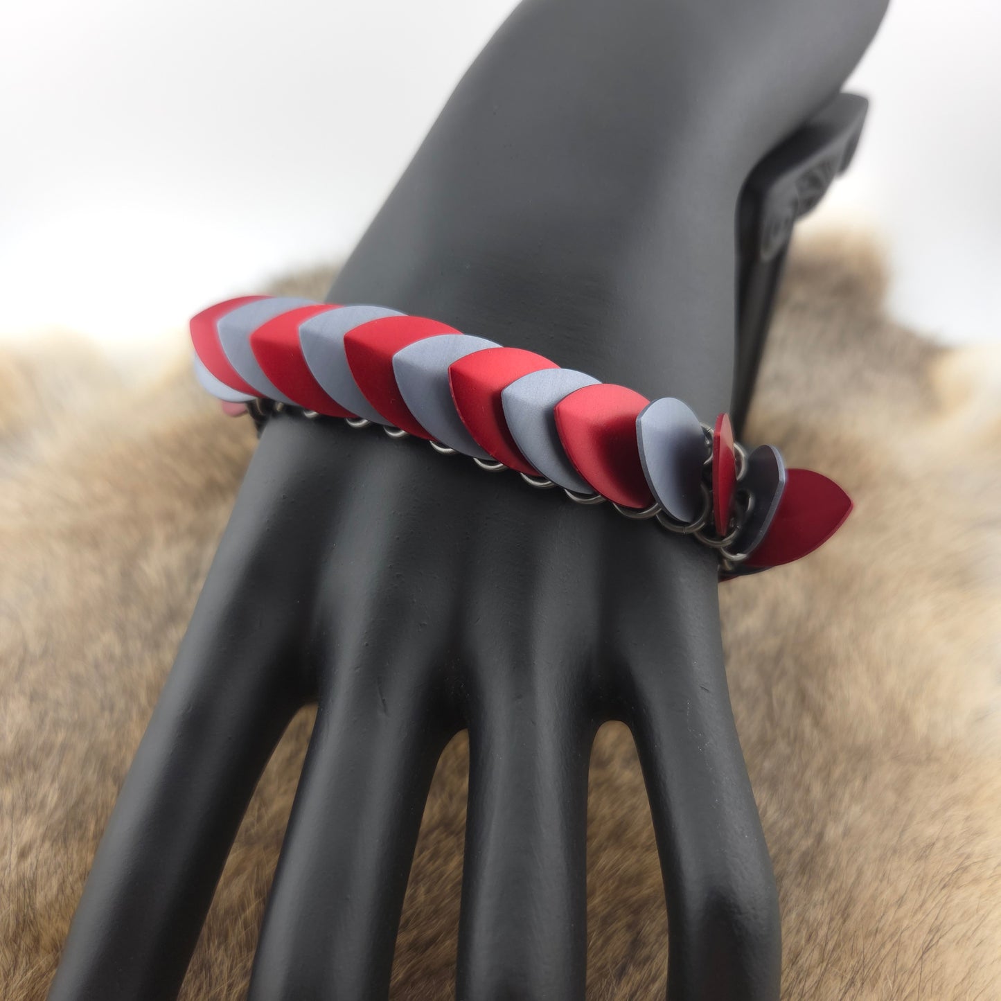 Dragon Scale Bracelet, with a stainless steel spine, premium anodized aluminum scales, and a solid stainless steel spring clasp shaped as a Dragon head.