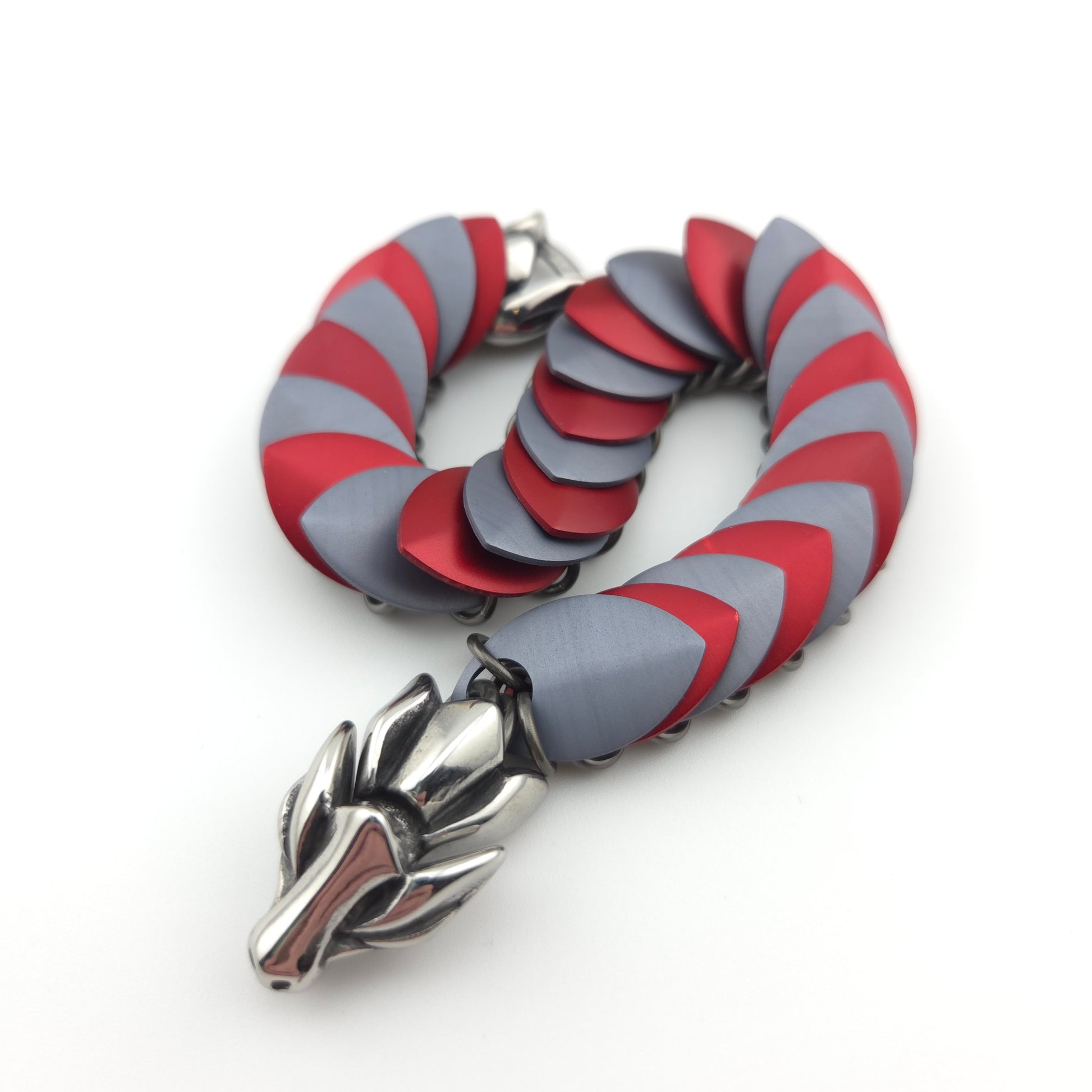 Dragon Scale Bracelet, with a stainless steel spine, premium anodized aluminum scales, and a solid stainless steel spring clasp shaped as a Dragon head.
