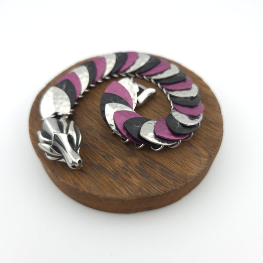 Dragon Scale Bracelet, with a stainless steel spine, premium anodized aluminum scales, and a solid stainless steel spring clasp shaped as a Dragon head.