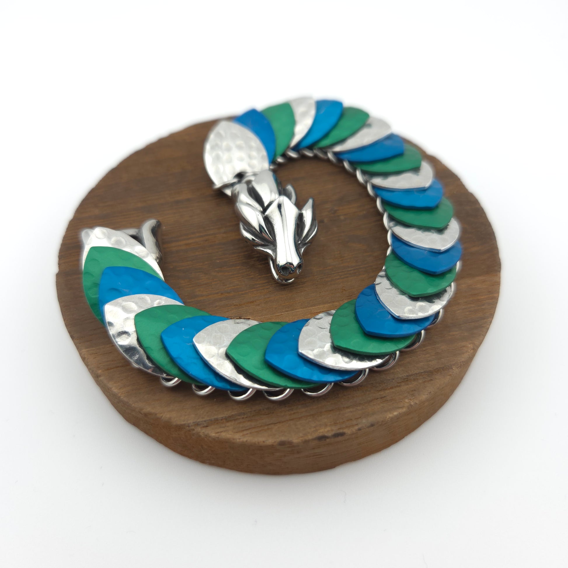 Dragon Scale Bracelet, with a stainless steel spine, premium anodized aluminum scales, and a solid stainless steel spring clasp shaped as a Dragon head.