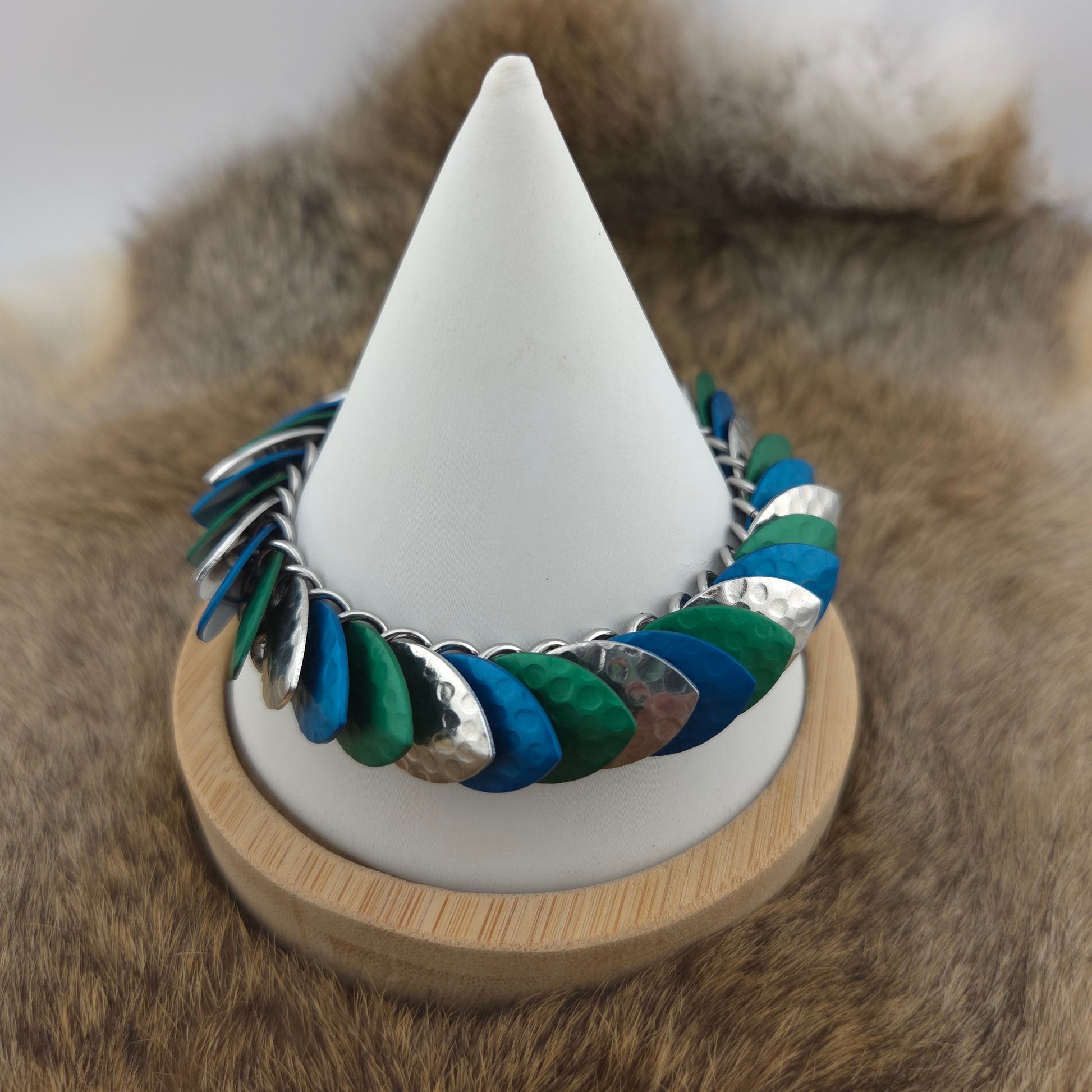Dragon Scale Bracelet, with a stainless steel spine, premium anodized aluminum scales, and a solid stainless steel spring clasp shaped as a Dragon head.