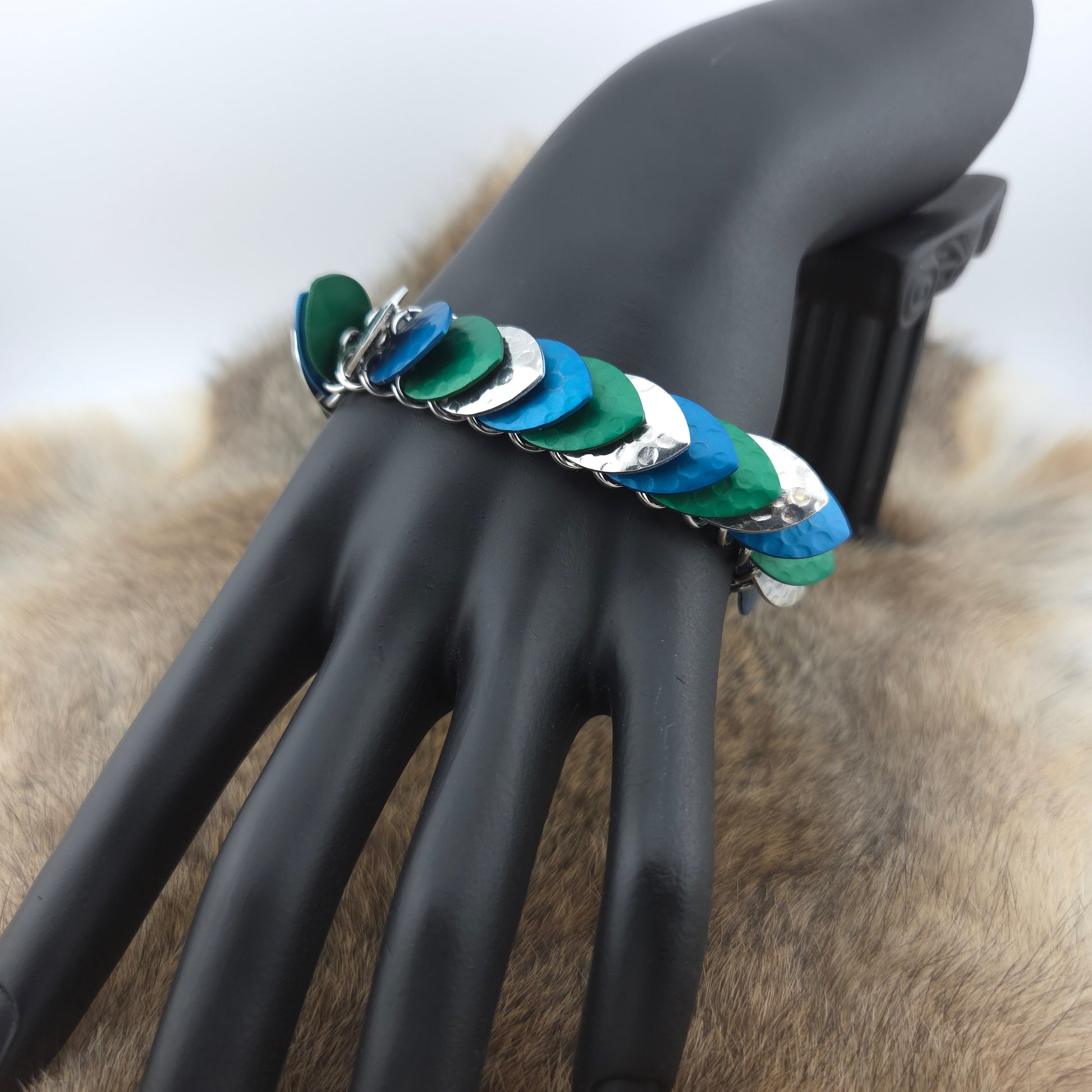 Dragon Scale Bracelet, with a stainless steel spine, premium anodized aluminum scales, and a solid stainless steel spring clasp shaped as a Dragon head.