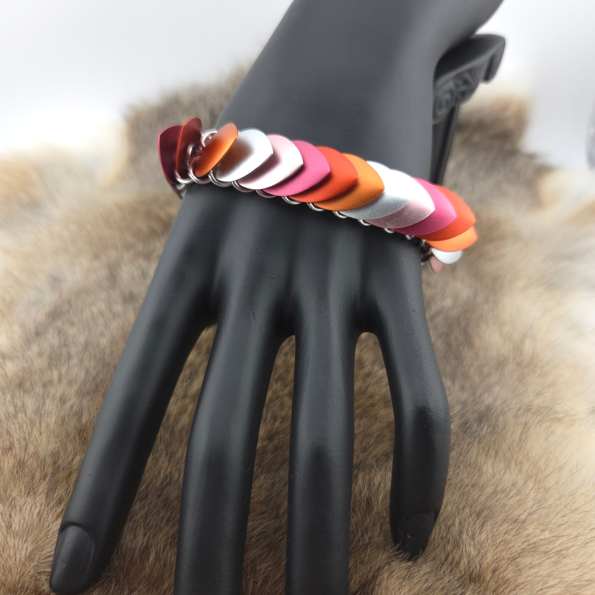 Dragon Scale Bracelet, with a stainless steel spine, premium anodized aluminum scales, and a solid stainless steel spring clasp shaped as a Dragon head.