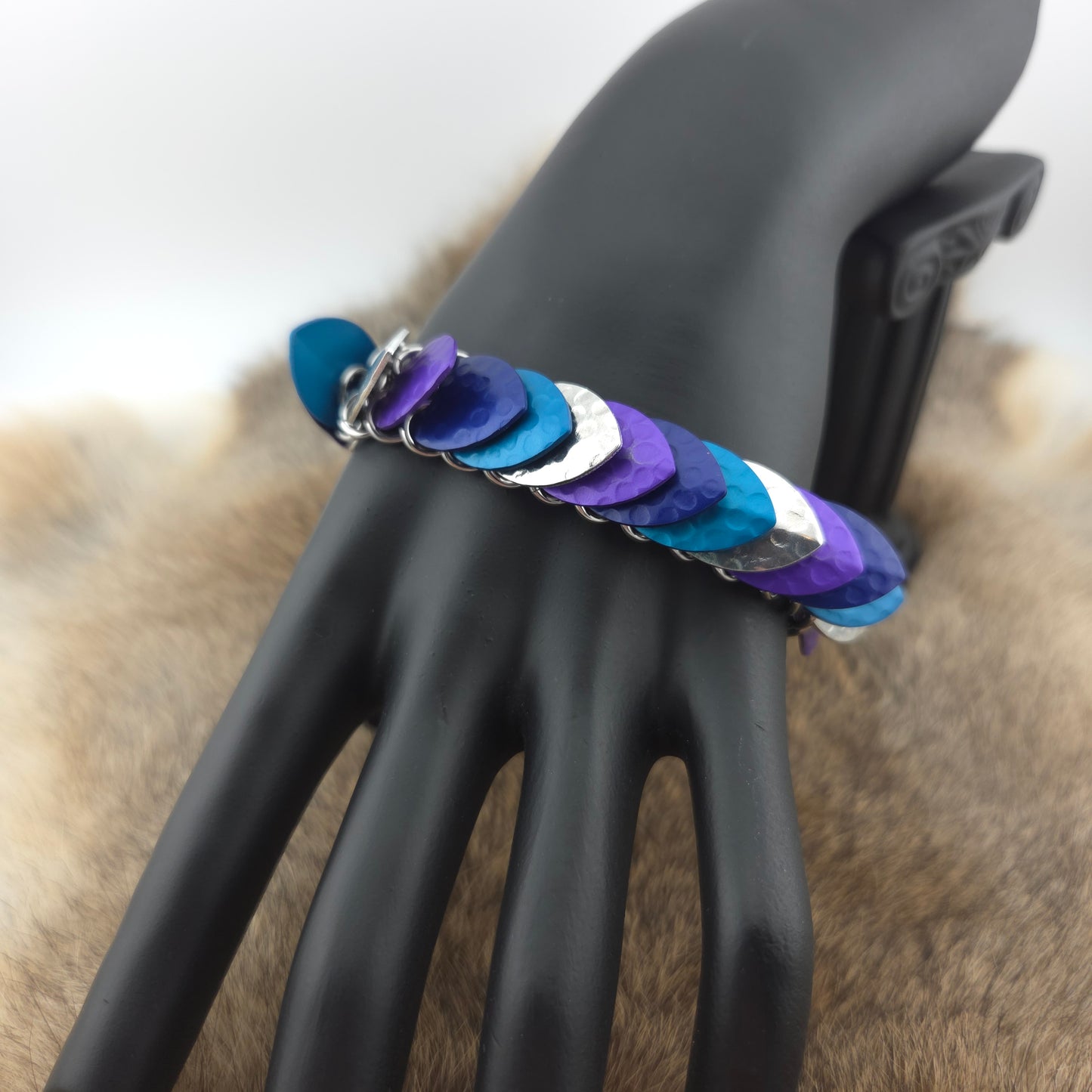 Dragon Scale Bracelet, with a stainless steel spine, premium anodized aluminum scales, and a solid stainless steel spring clasp shaped as a Dragon head.