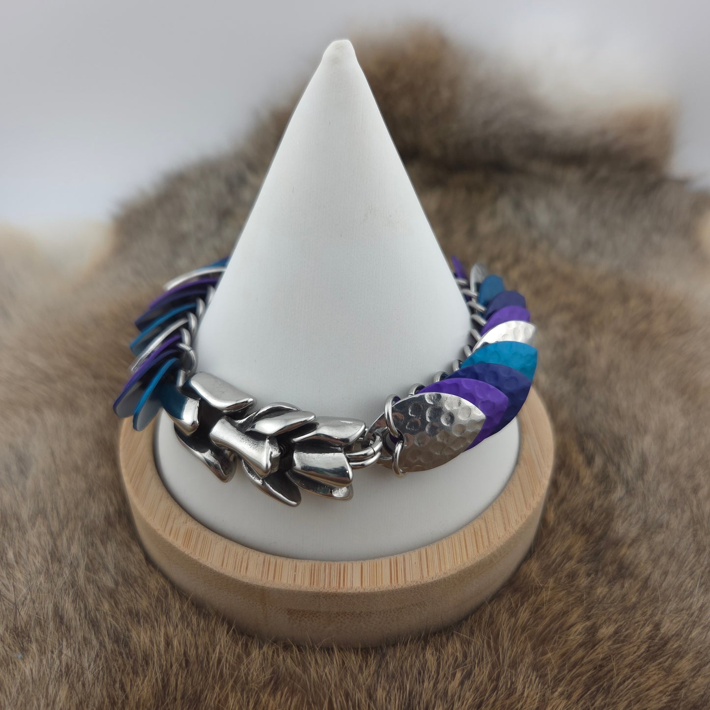 Dragon Scale Bracelet, with a stainless steel spine, premium anodized aluminum scales, and a solid stainless steel spring clasp shaped as a Dragon head.