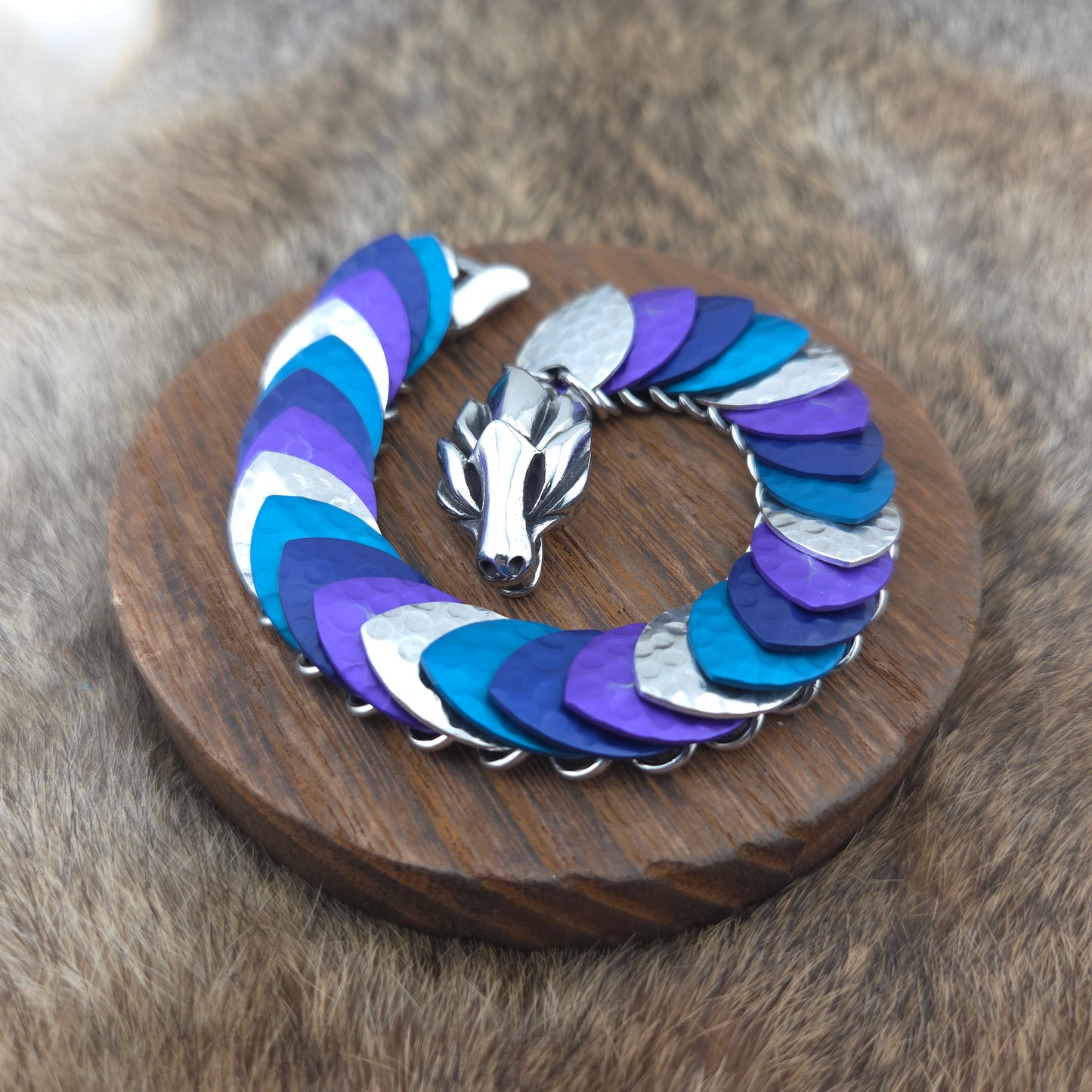 Dragon Scale Bracelet, with a stainless steel spine, premium anodized aluminum scales, and a solid stainless steel spring clasp shaped as a Dragon head.