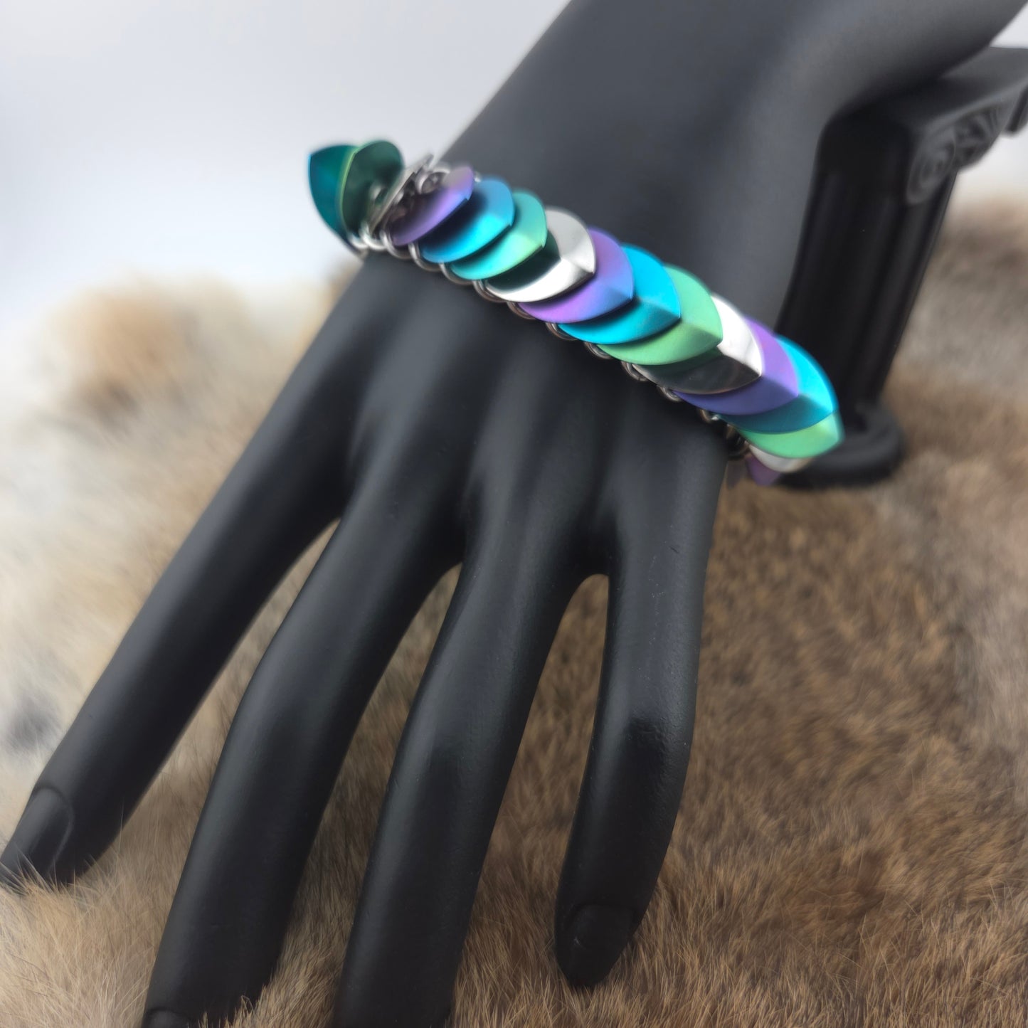 Dragon Scale Bracelet, handwoven with a stainless steel spine, silver, purple, teal, and green scales.
