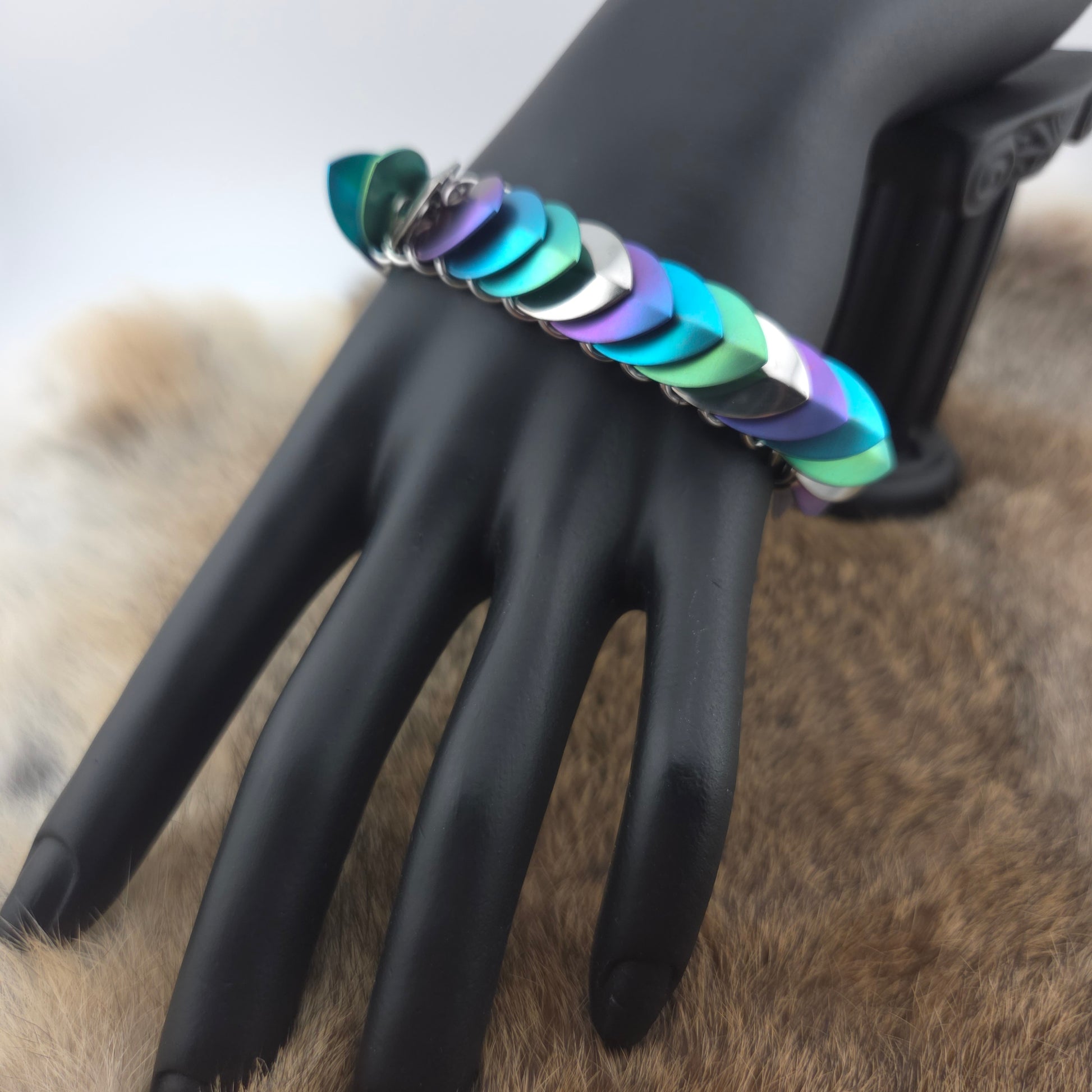 Dragon Scale Bracelet, handwoven with a stainless steel spine, silver, purple, teal, and green scales.
