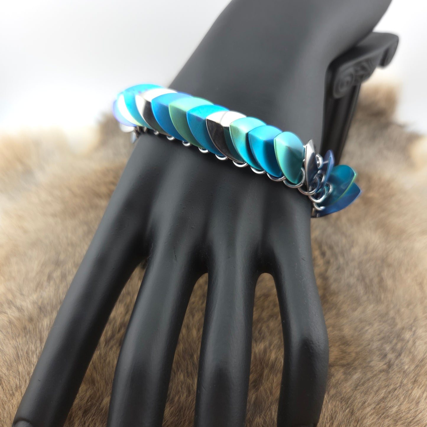 Dragon Scale Bracelet, with a stainless steel spine, anodized titanium  scales, and a solid stainless steel spring clasp shaped as a Dragon head.