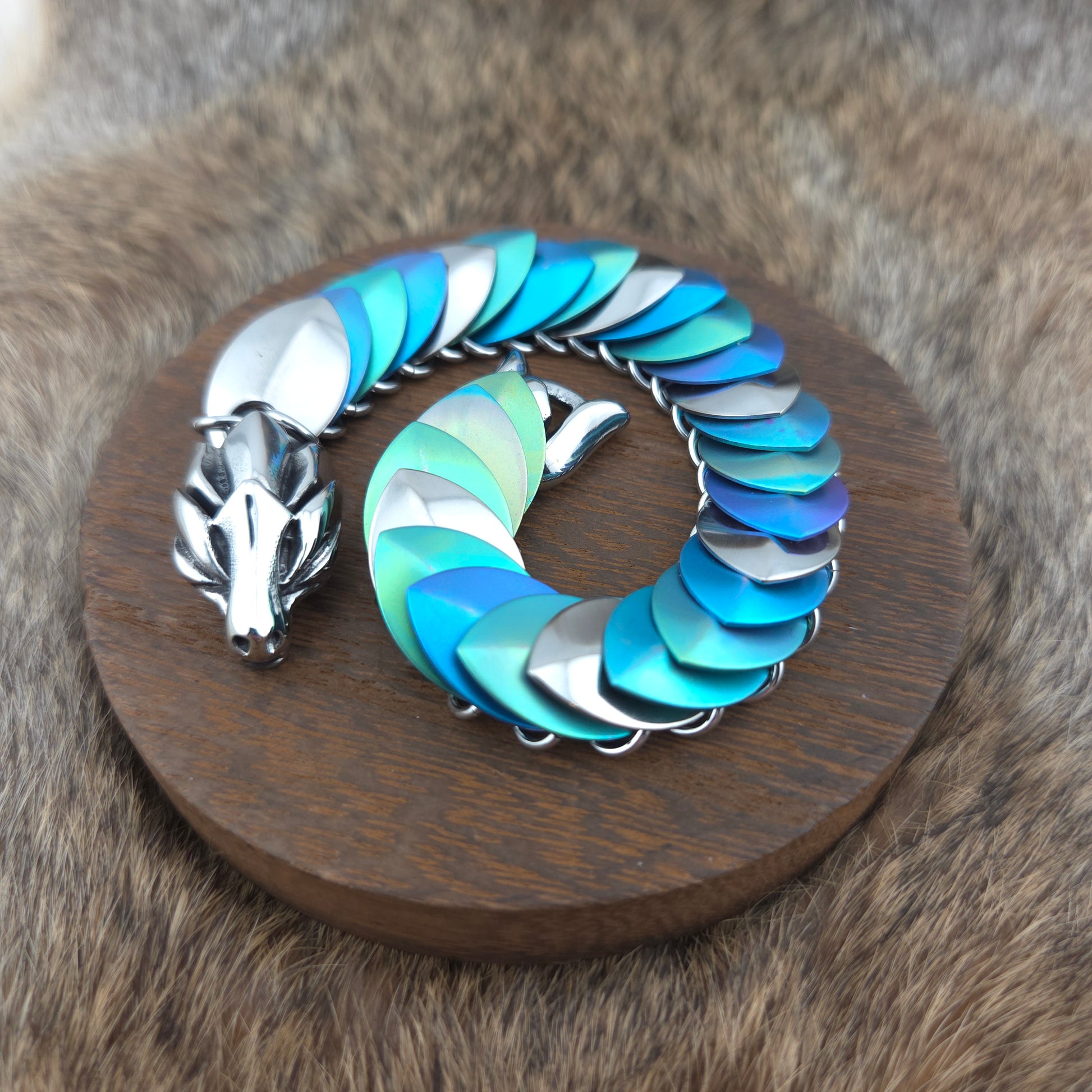 Dragon Scale Bracelet, with a stainless steel spine, anodized titanium  scales, and a solid stainless steel spring clasp shaped as a Dragon head.