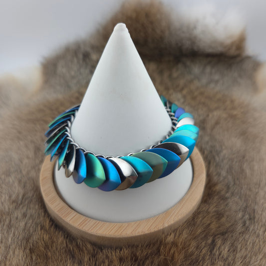 Dragon Scale Bracelet, with a stainless steel spine, anodized titanium  scales, and a solid stainless steel spring clasp shaped as a Dragon head.