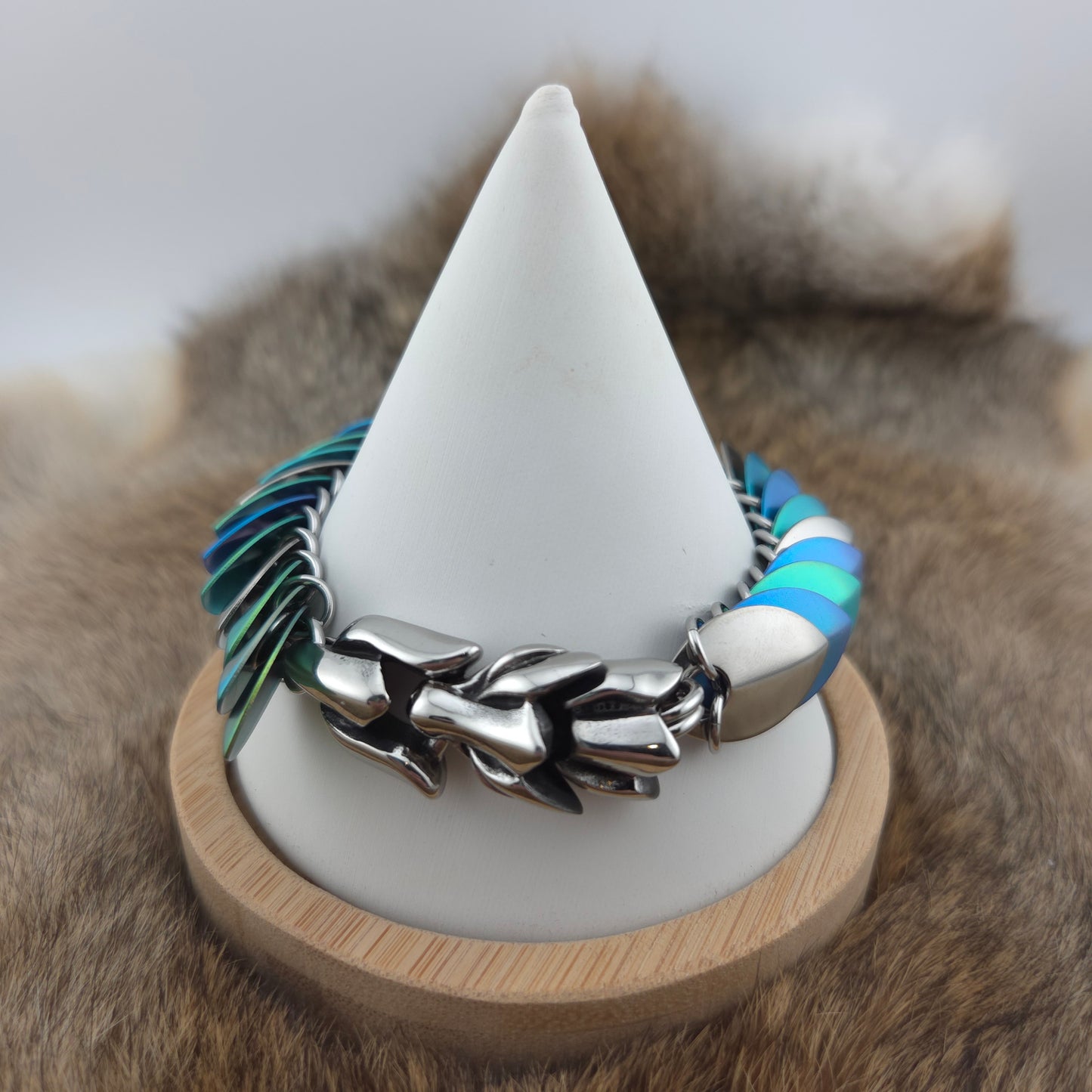 Dragon Scale Bracelet, with a stainless steel spine, anodized titanium  scales, and a solid stainless steel spring clasp shaped as a Dragon head.