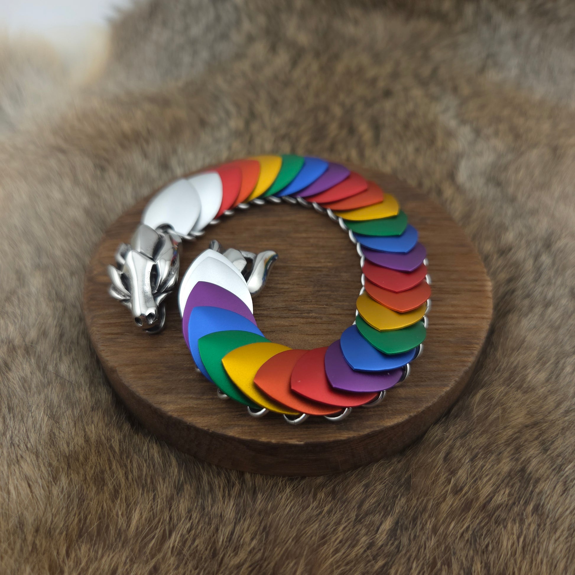 Rainbow Pride Dragon Scale Bracelet, with a stainless steel spine, premium anodized aluminum scales, and a solid stainless steel spring clasp shaped as a Dragon head.