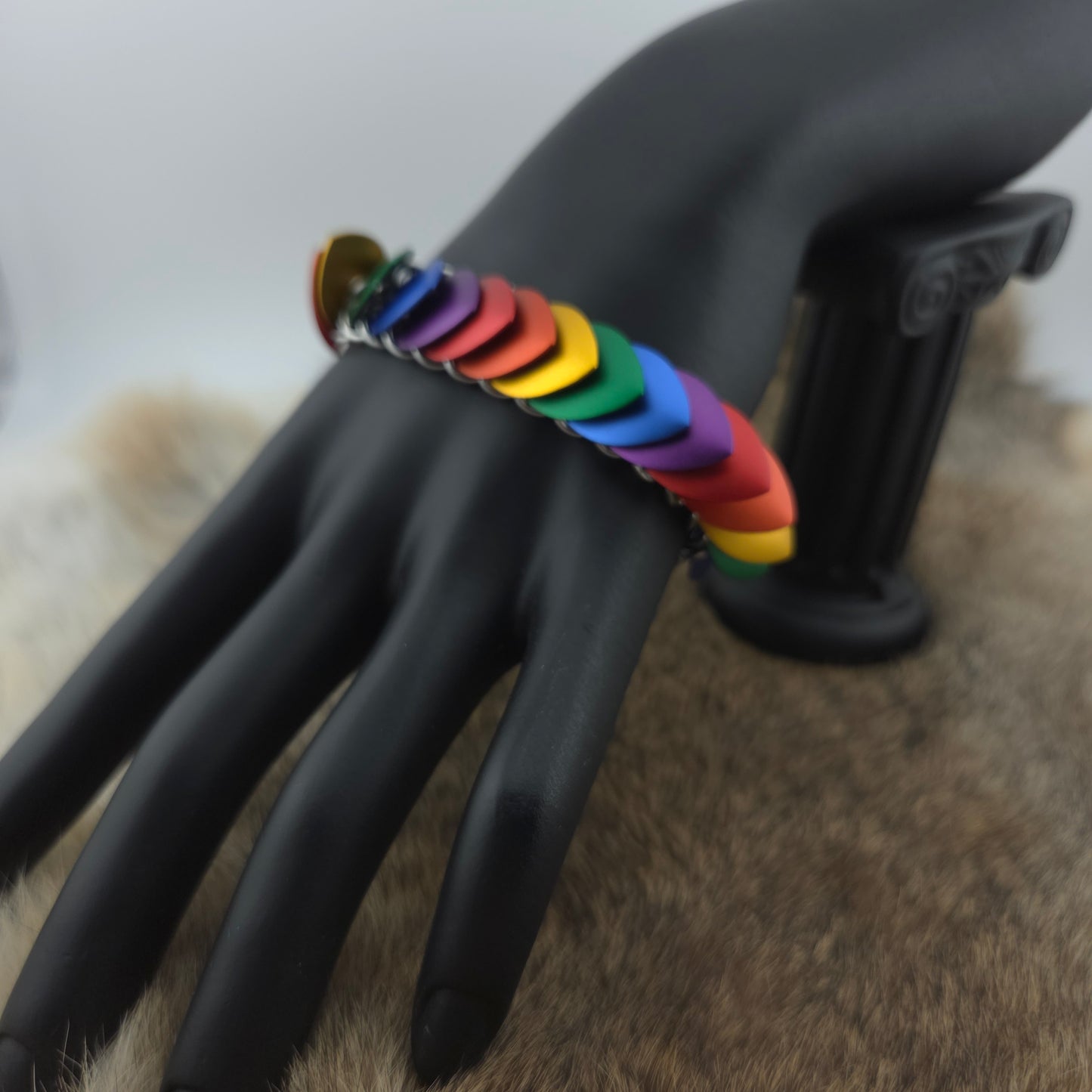 Rainbow Pride Dragon Scale Bracelet, with a stainless steel spine, premium anodized aluminum scales, and a solid stainless steel spring clasp shaped as a Dragon head.
